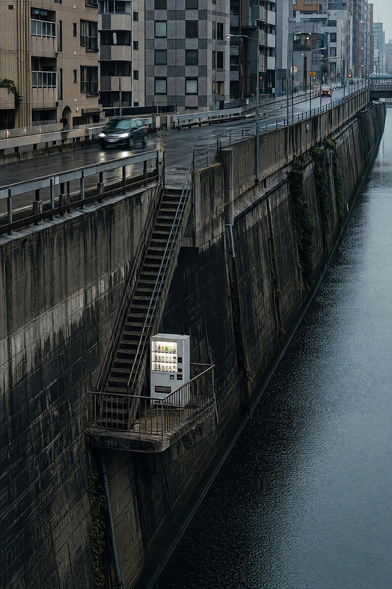Vending machine placed on a very strange place by a canal in Japan