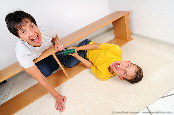 Mutter und Sohn beim Möbel zusammenbauen, beide schreien - Mother and son assembling furniture, both are screaming