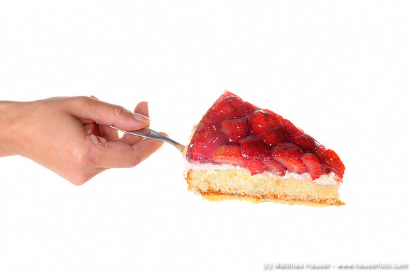 Weibliche Hand serviert ein Stück Erdbeertorte, Erdbeerkuchen auf einem Tortenheber - Woman's hand serving a piece of strawberry cake on a cake server